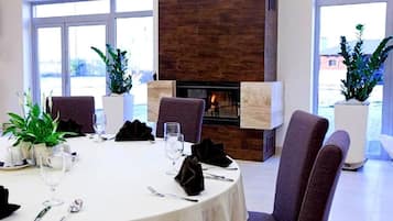 Comedor con una mesa redonda, sillas y chimenea.