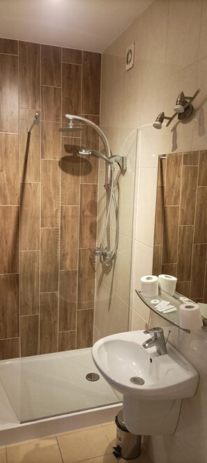 Un baño moderno con ducha, bañera y lavamanos.