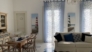 A room with a dining table, chairs, a sofa, and a cabinet. - La Casa di Ada&Gigi Vacanze (Porto Cesareo)