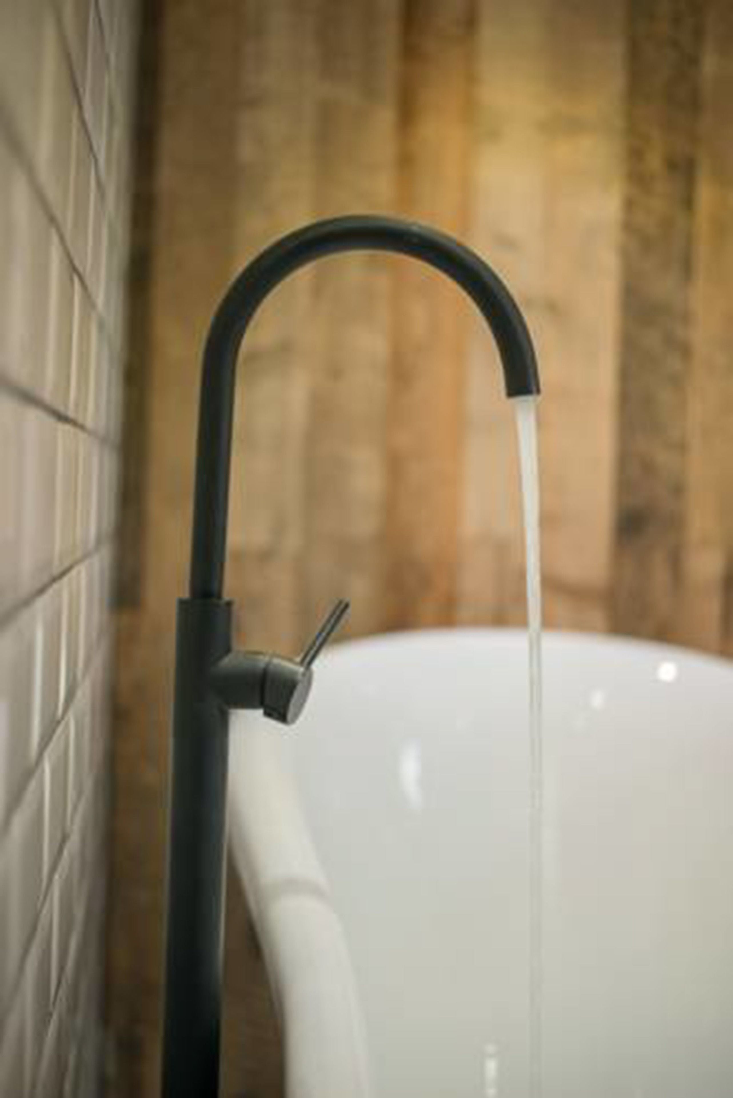 A bathroom with a white sink and a black faucet.