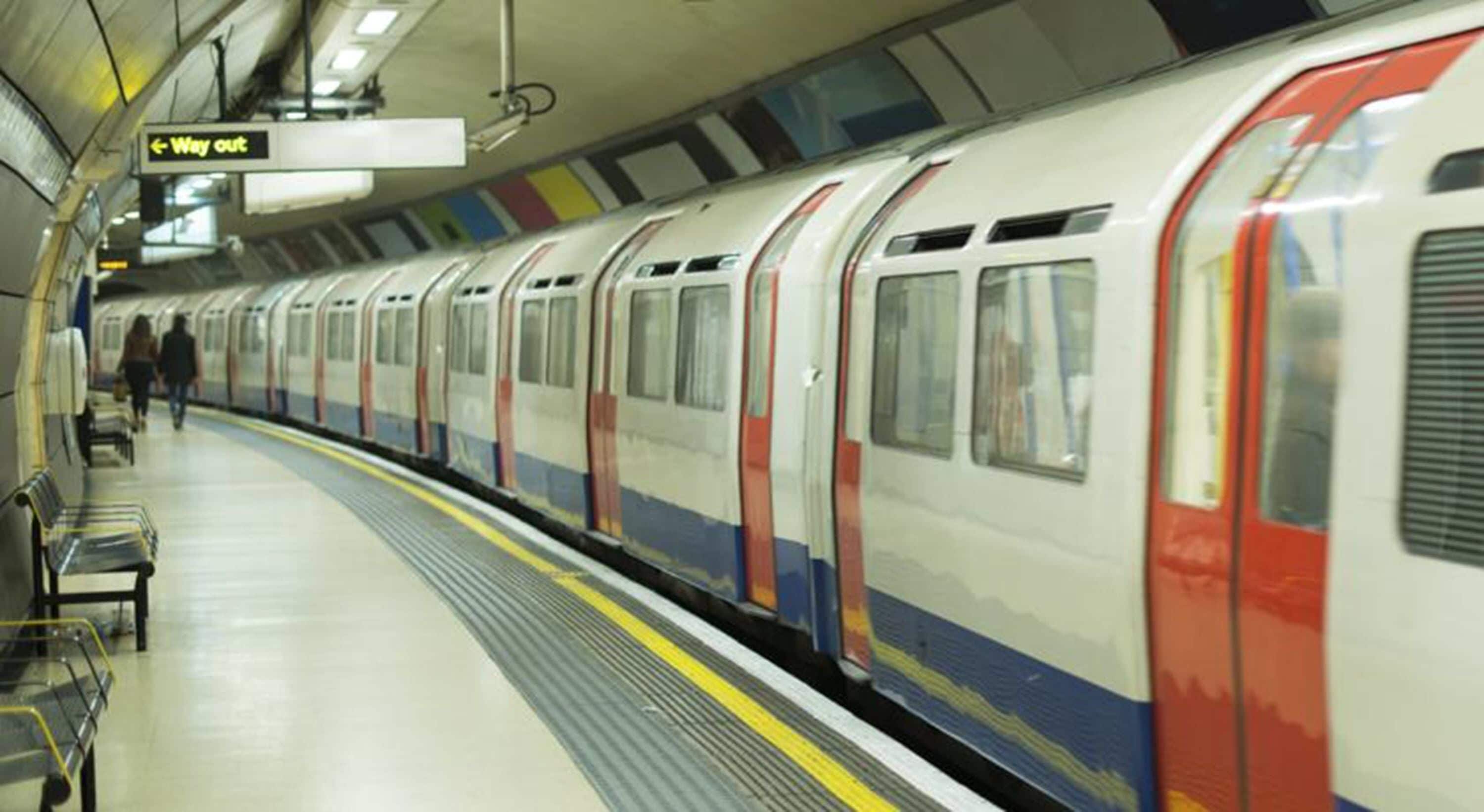 A subway station with a train, benches, and a 'Way out' sign.