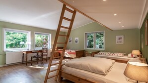 Ein Schlafzimmer mit einer Holzleiter, einem Schreibtisch und einem Bett.