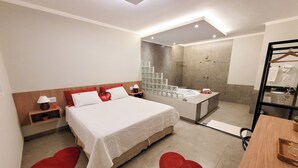 Una habitación de hotel moderna con una cama grande, un baño separado con bañera y ducha.