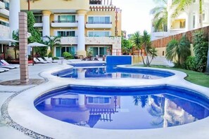 Una piscina al aire libre, sillones reclinables de piscina