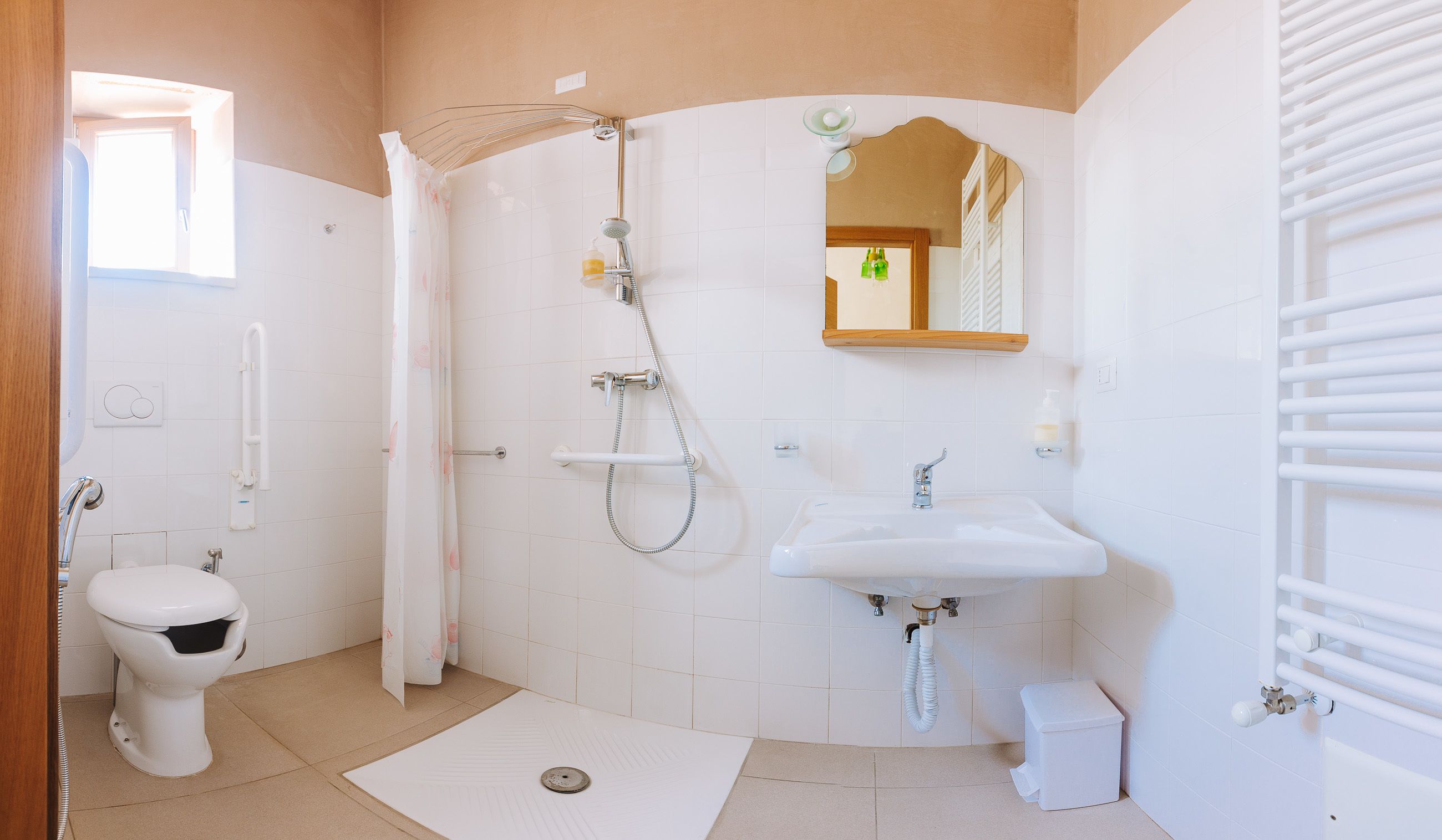 Ein Badezimmer mit Toilette, Dusche, Waschbecken und Spiegel.