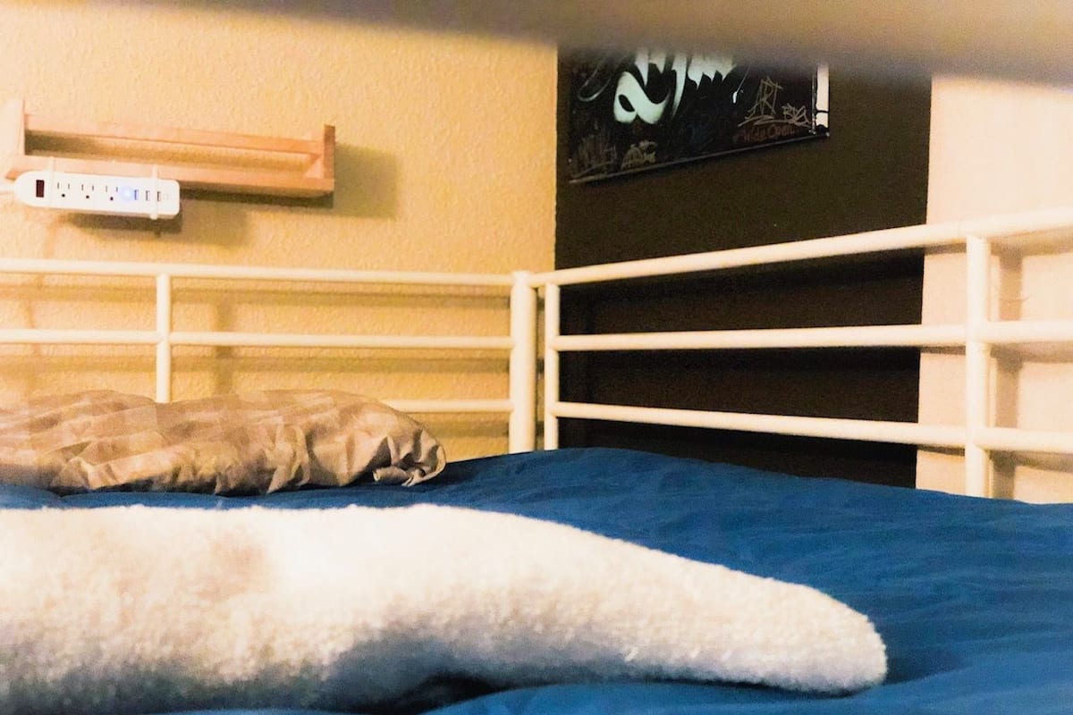 Ein Bett mit einer blauen Matratze und einer weißen Decke.