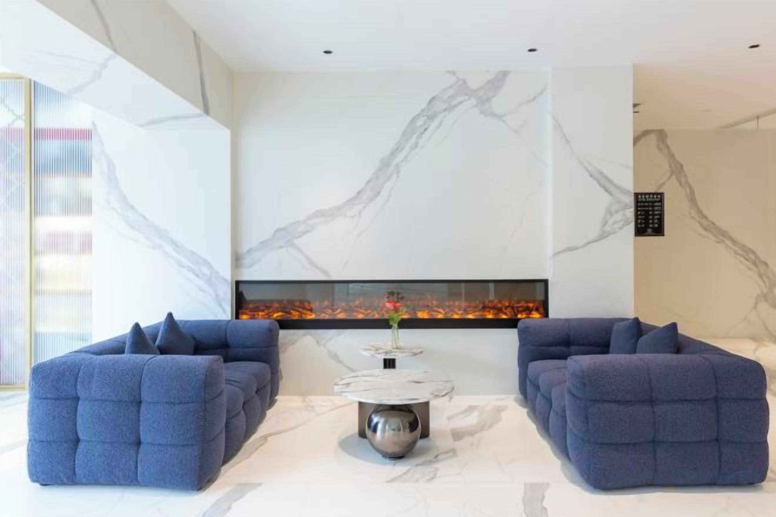 A modern living room with a fireplace, two sofas, and a coffee table.
