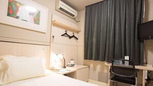 A hotel room with a bed, a desk, a chair, a TV, an air conditioner, and a window with curtains. - JIN Jiang INN Pingan Street (Shijiazhuang)