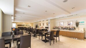 A modern hotel lobby with a reception desk, multiple dining tables, and chairs. - JIN Jiang INN Pingan Street (Shijiazhuang)