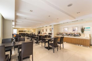 A modern hotel lobby with a reception desk, multiple dining tables, and chairs. - JIN Jiang INN Pingan Street (Shijiazhuang)