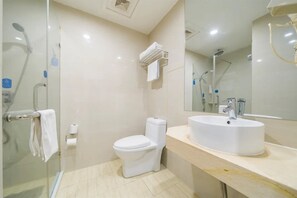 Un bagno moderno con doccia vetrata, un water e un lavabo con specchio sopra.