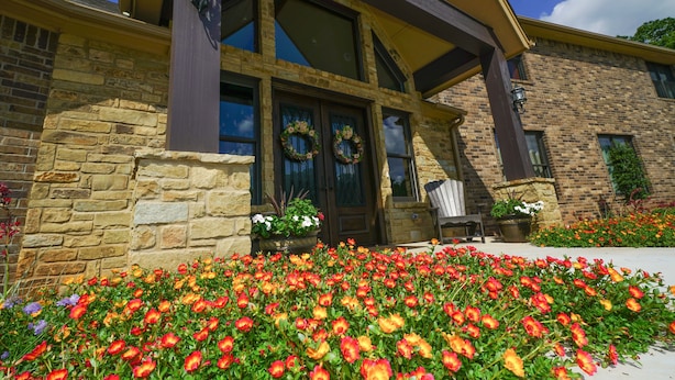A stone building with a yellow roof, large windows, and a front porch with a bench. - Hidden Meadows B&B (Stillwater)