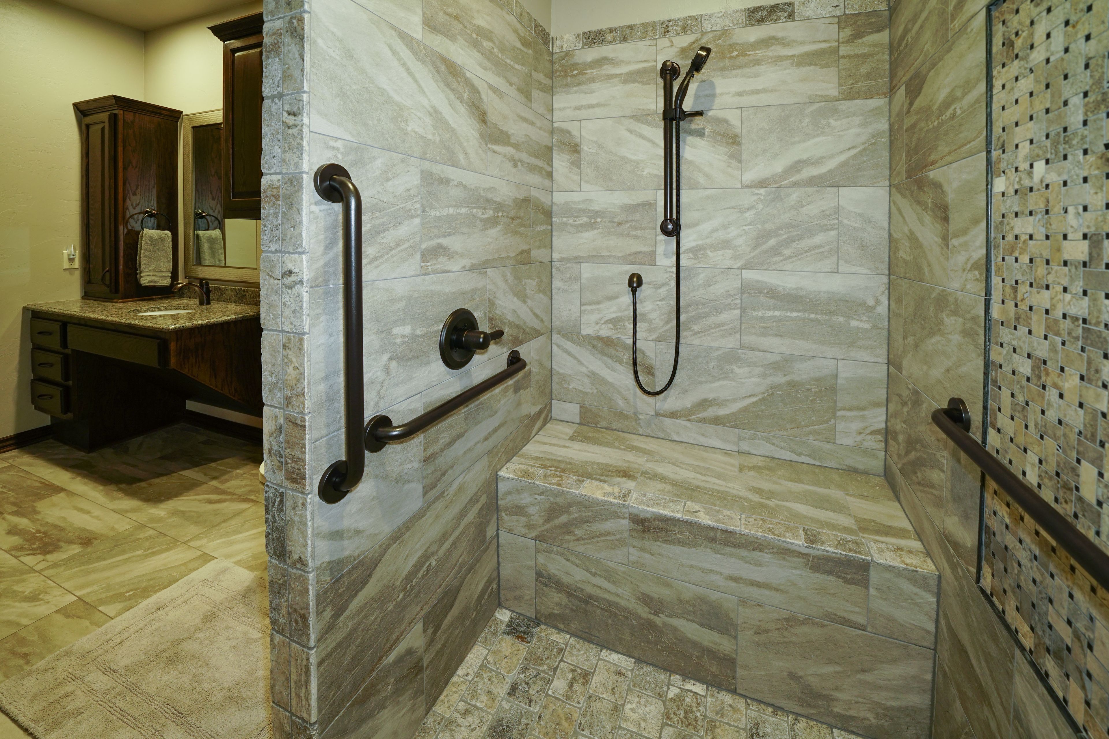 A bathroom with a shower, a vanity with a mirror, and a towel rack.