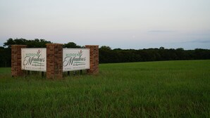 Two brick signs for Hidden Meadows Bed & Breakfast in a grassy field. - Hidden Meadows B&B (Stillwater)