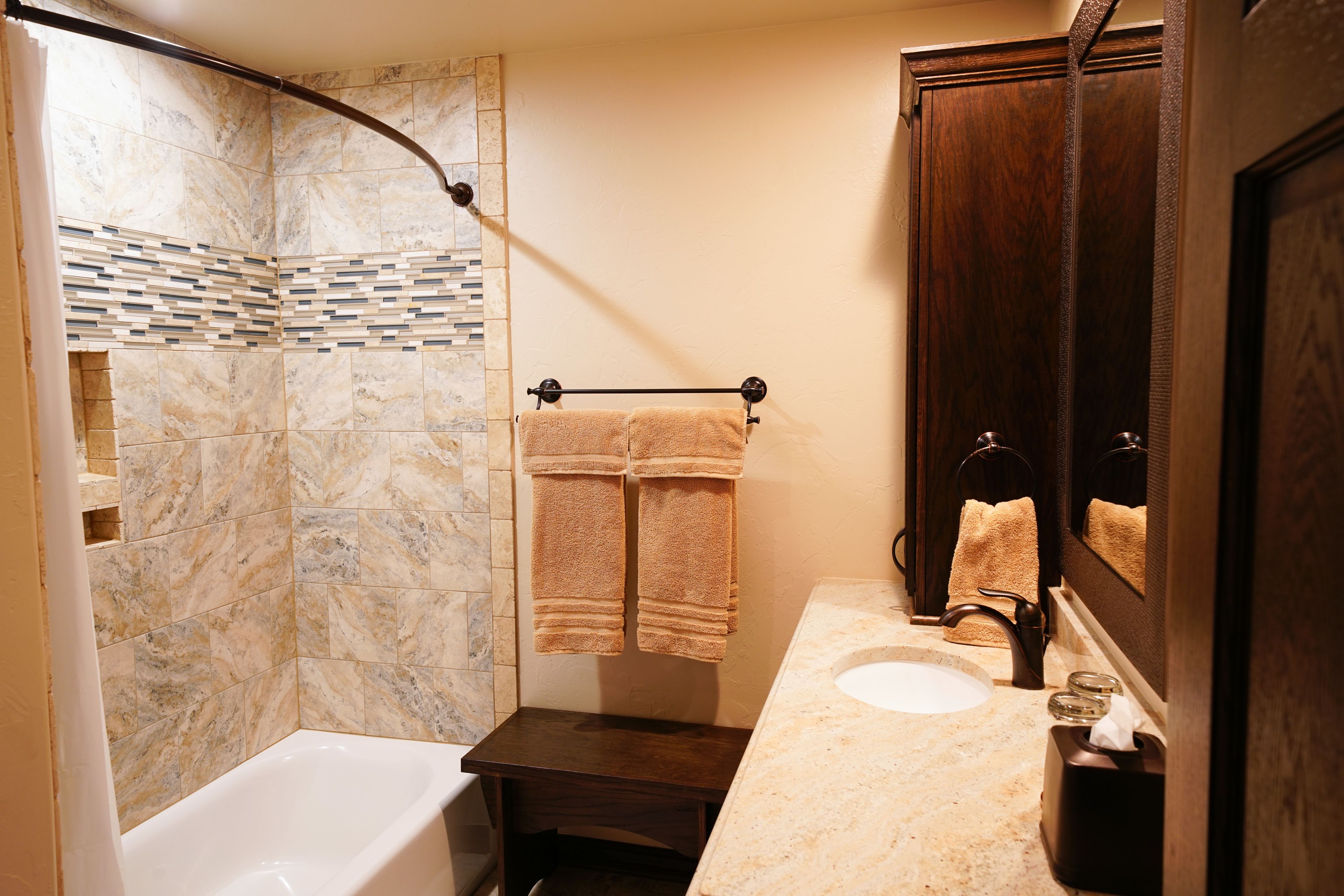A bathroom with a bathtub, a shower, a sink, and a mirror.