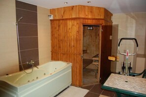 Ein Badezimmer mit einer Holzwanne, einer Dusche und einer Toilette.