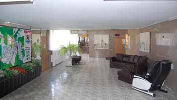 Un vestíbulo con mapa, zona de estar y sillón de masajes.