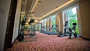 Ein Fitnessstudio mit Laufbändern, Crosstrainern und einer Gewichtheberstation.