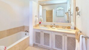 A bathroom with a bathtub, two sinks, a large mirror, and a shower area. - The Summer House, Sugar Hill Resort (Holetown)