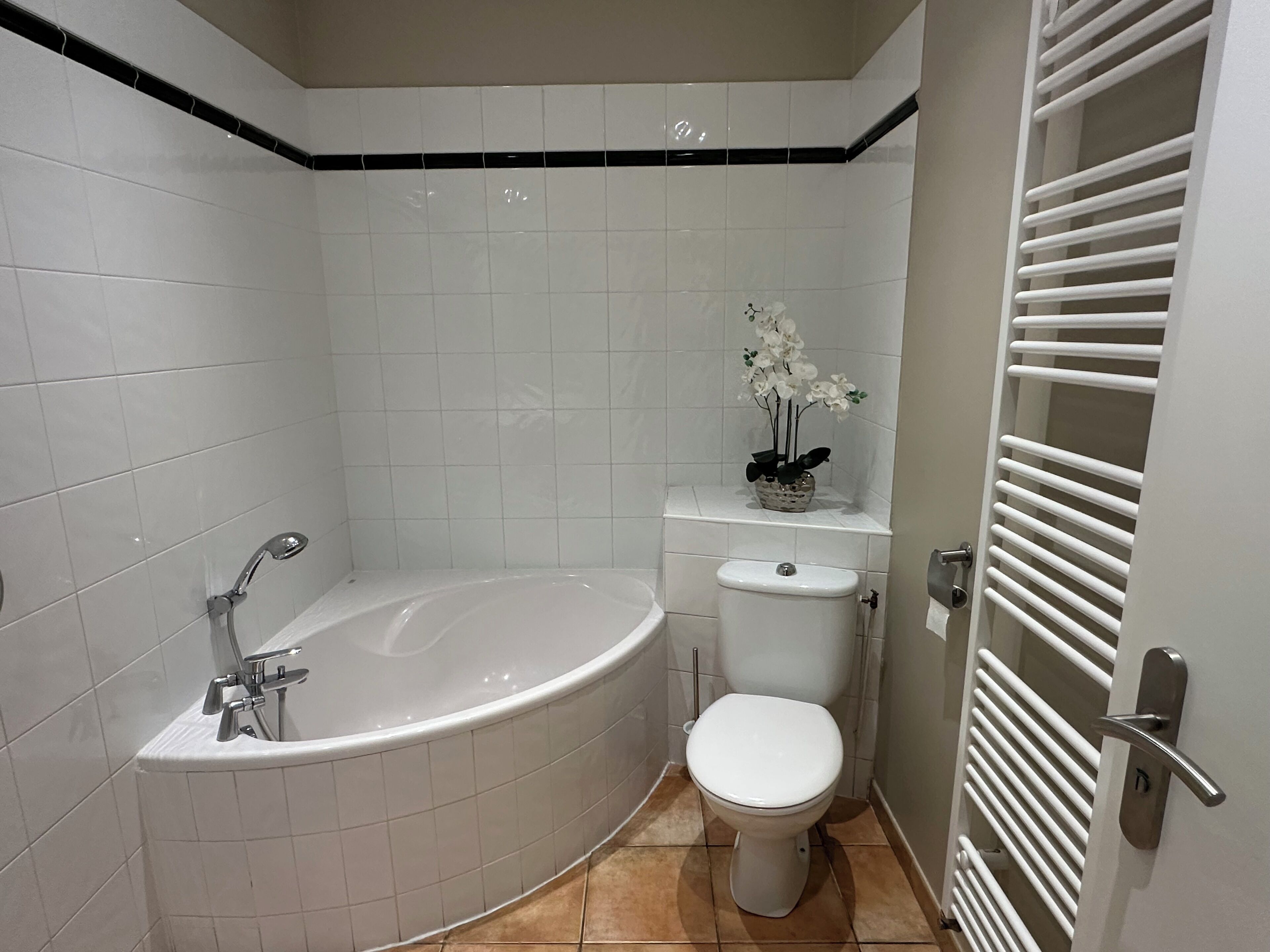 Een moderne badkamer met een vrijstaand bad, toilet en wastafel.