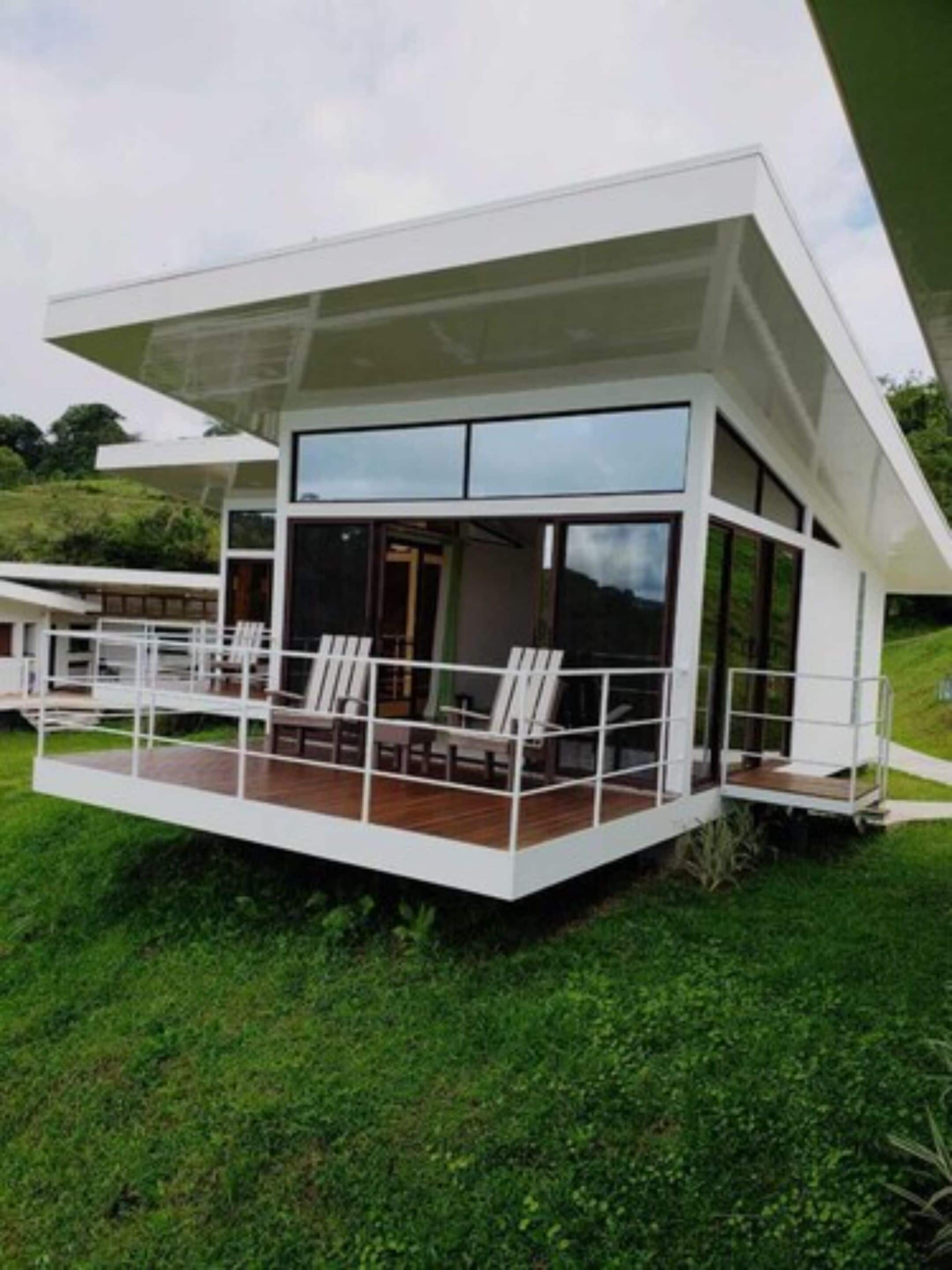 A modern house with a large deck and multiple windows.