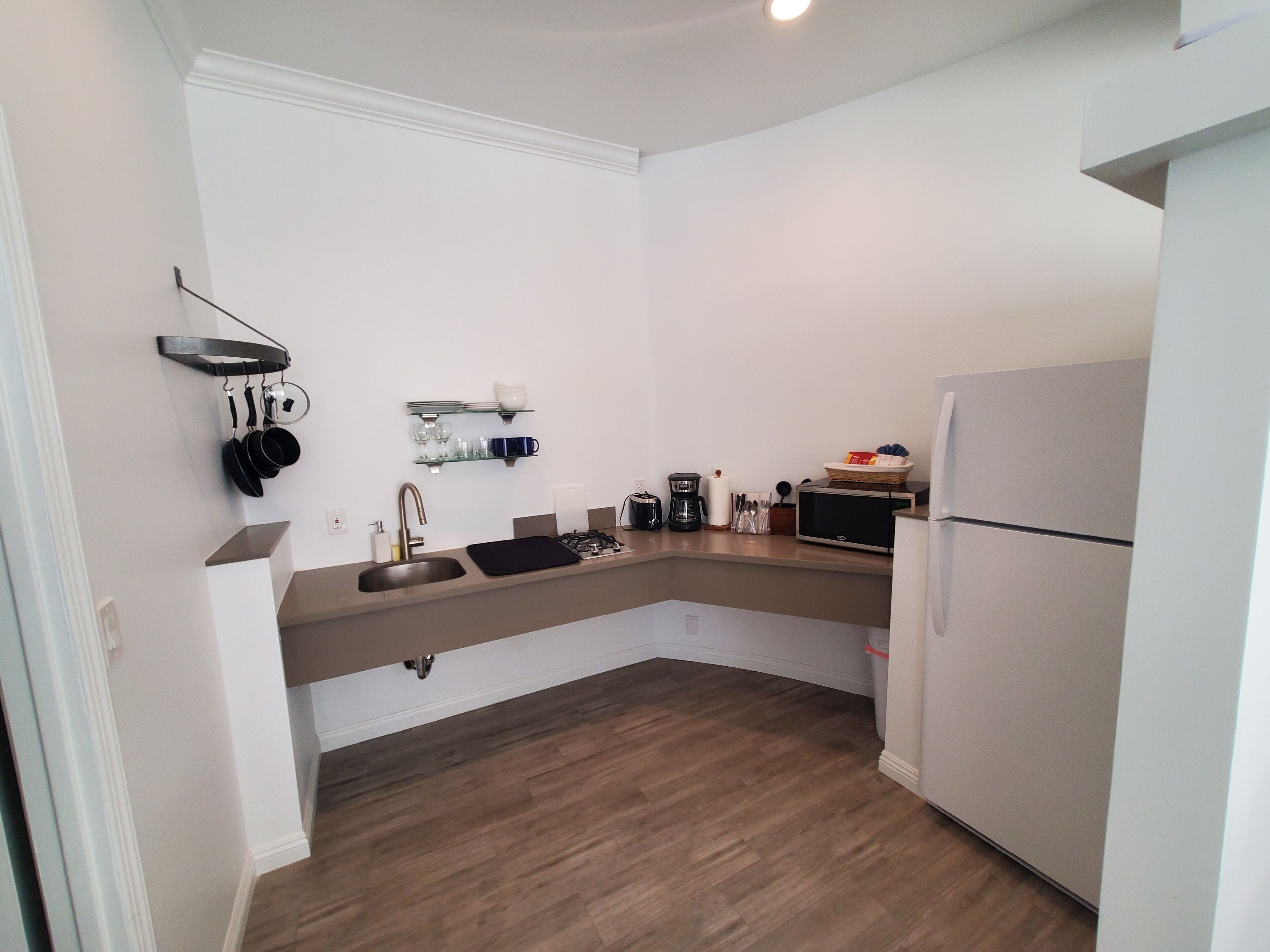 Una cucina moderna con lavandino, piano cottura, microonde e frigorifero.