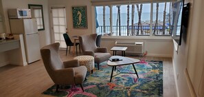 Suíte estúdio luxo, para não fumantes, vista para o oceano | Sala de estar | TV de tela plana 32 polegadas com canais a cabo, TV