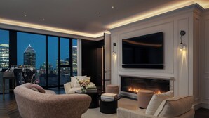 A modern living room with a fireplace, a large TV, and a city view. - Four Seasons Hotel Montreal (Montreal)