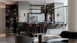 A modern bar area with seating and a staircase leading to a mezzanine. - Four Seasons Hotel Montreal (Montreal)