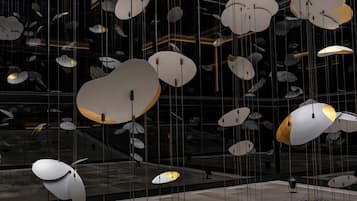 A modern interior with hanging spherical light fixtures and a reflective glass wall.
