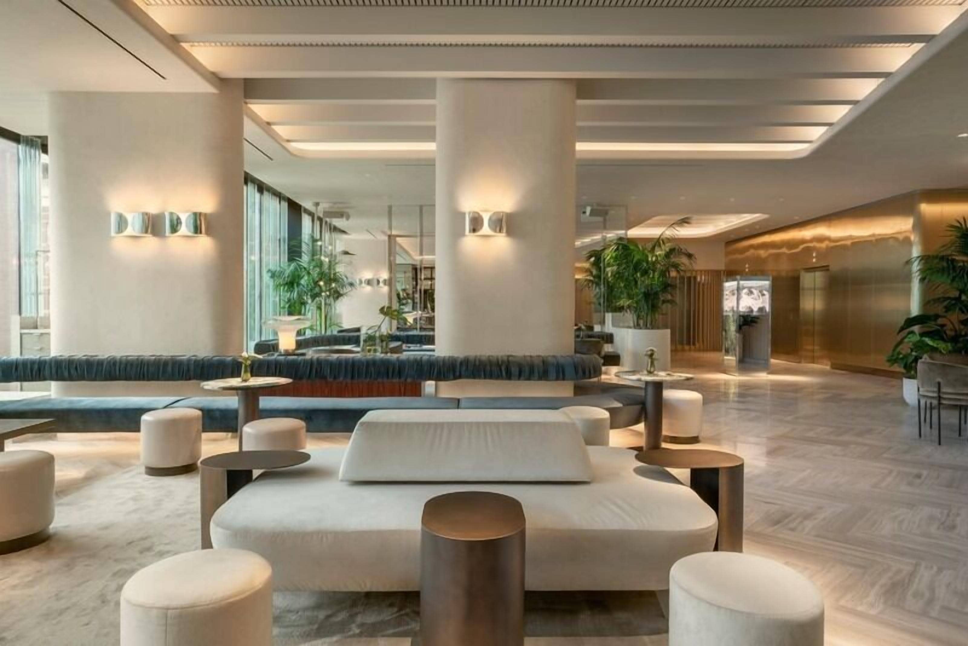 Een ruime lobby met een centraal ziteiland, grote kolommen en een modern design.