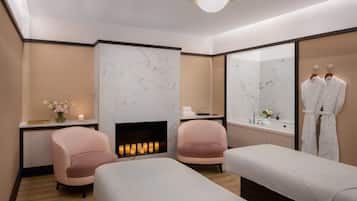 Un moderno spa con dos camillas de masaje, una chimenea y un espejo grande.