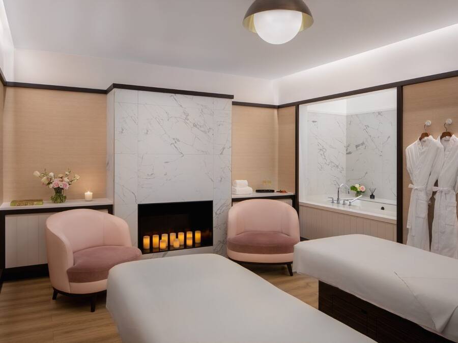 Un moderno spa con dos camillas de masaje, una chimenea y un espejo grande.