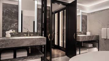 Une salle de bain moderne avec deux lavabos, un grand miroir et une baignoire.