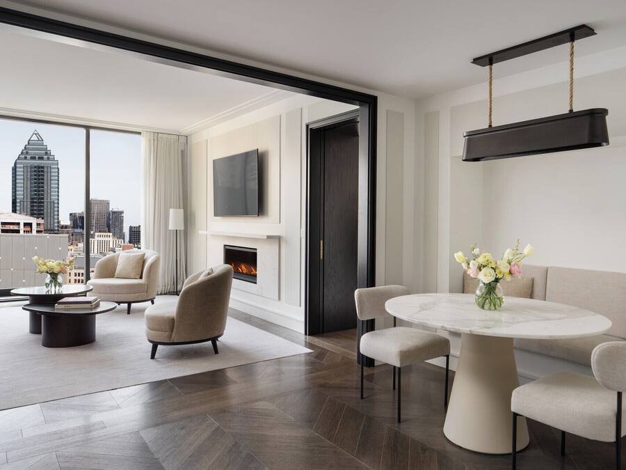 A modern living room with a fireplace, a round dining table, and a sofa.