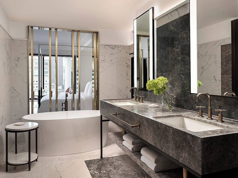 Ein modernes Badezimmer mit einer großen Badewanne, zwei Waschbecken und einem großen Spiegel.