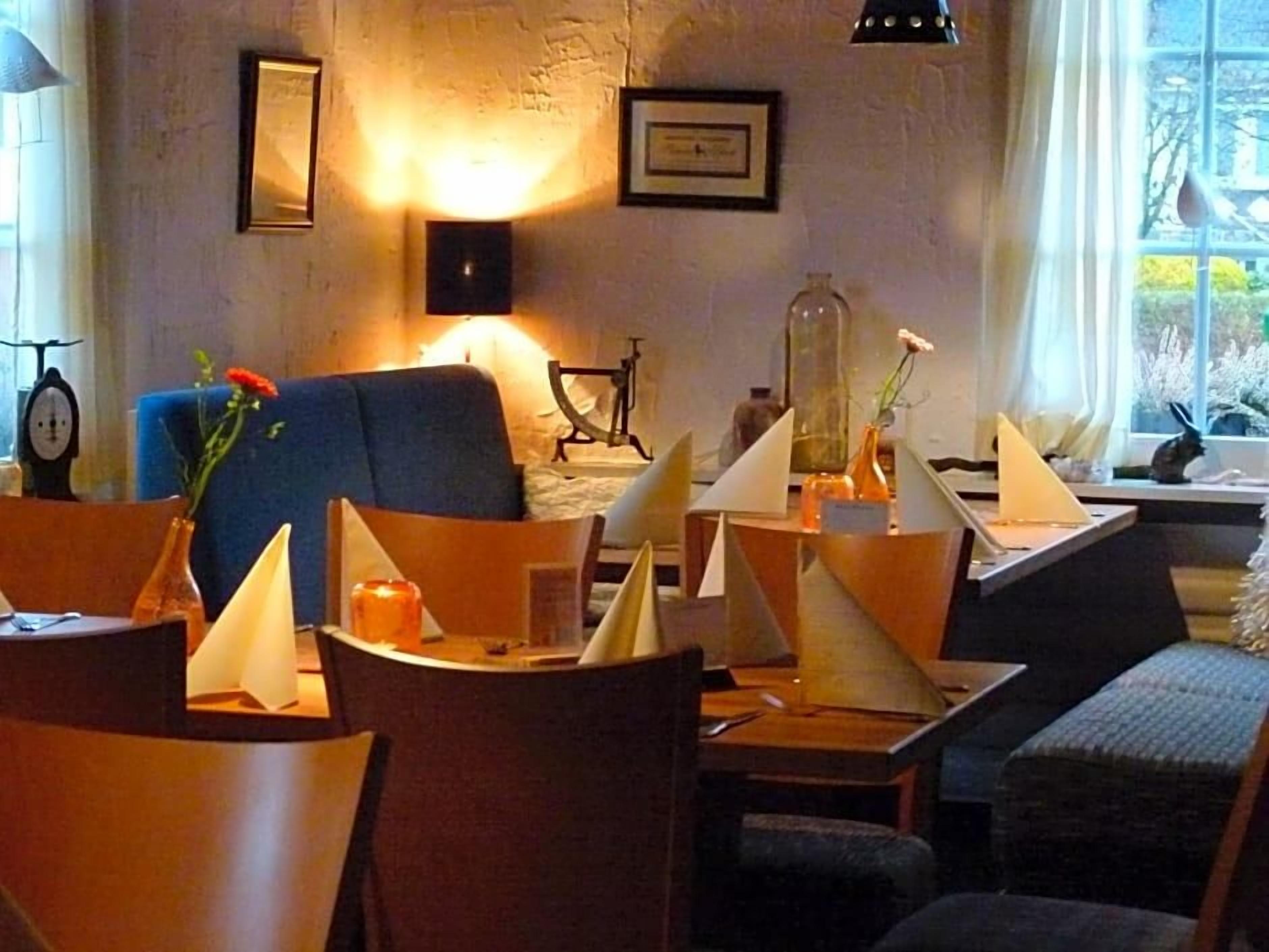 Un comedor con mesas, sillas y un sofá azul.