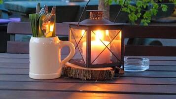 Un banco de madera con un farol y una taza encima.