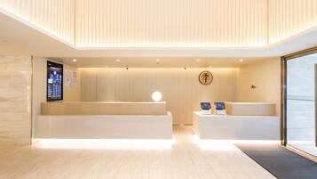 A modern reception area with a wooden reception desk, a digital display, and a reception counter.