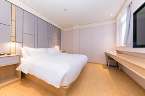 A modern bedroom with a bed, bedside tables, a desk, and a large window.