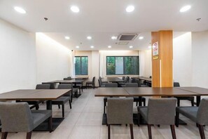 A conference room with multiple tables and chairs, large windows, and a wooden accent wall. - HanTing Hotel (Shanghai Xizang North Road Subway Station) (Shanghai)
