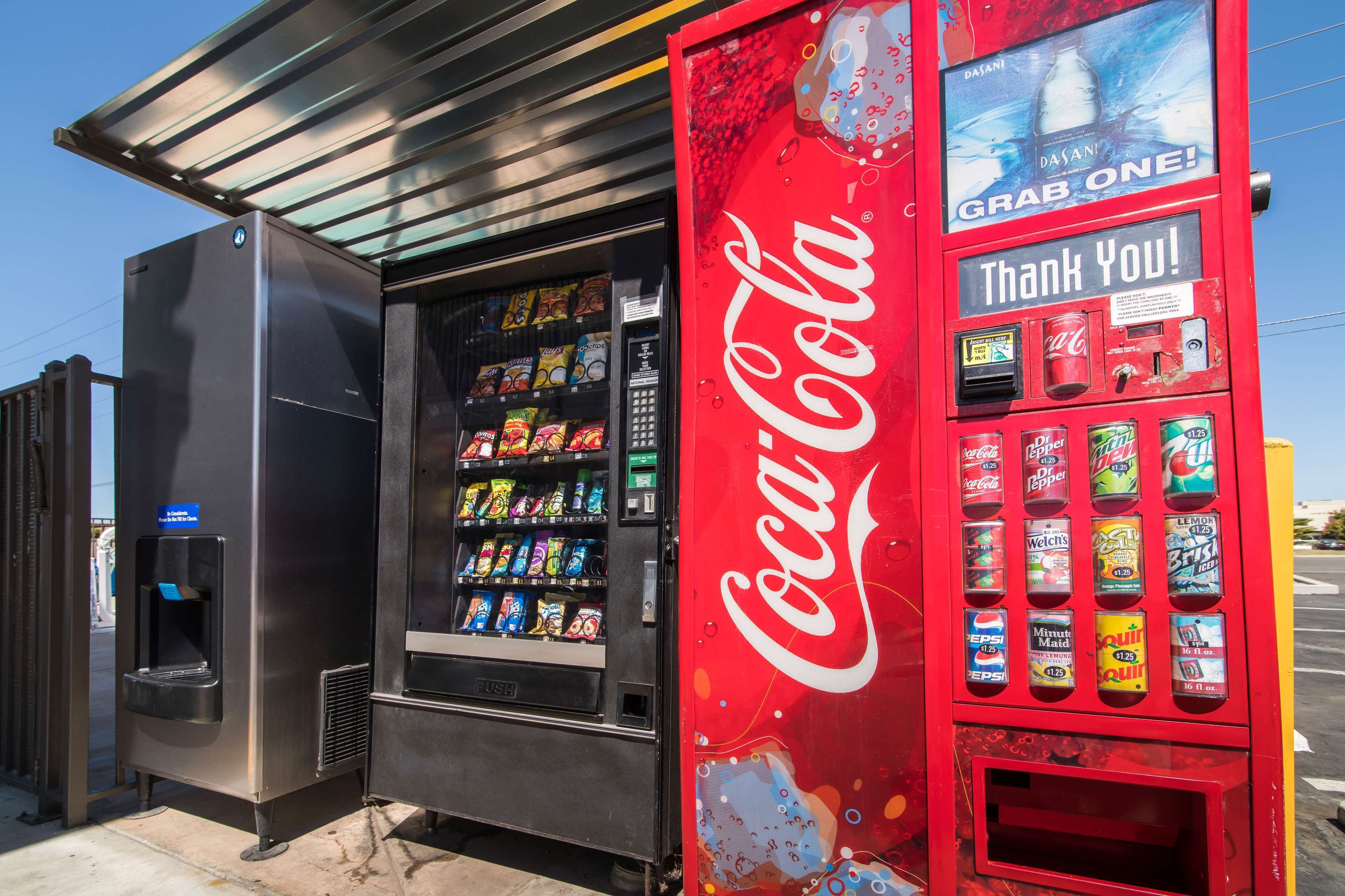 A vending machine with a Coca-Cola logo and a Dasani water dispenser.