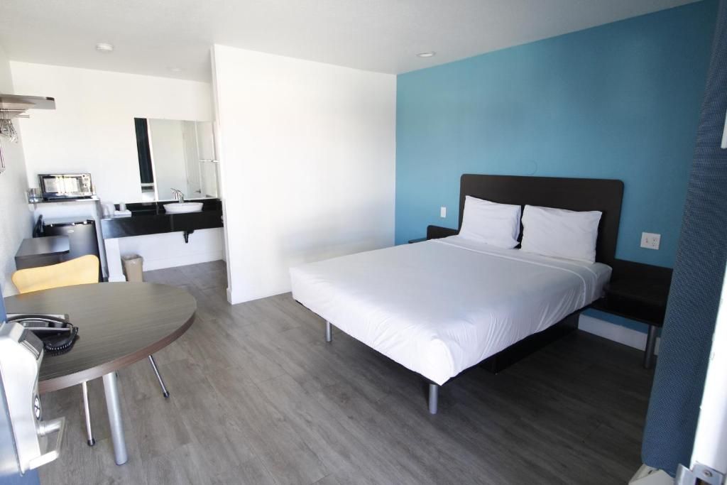 Une chambre d’hôtel avec un lit, un bureau et une chaise.