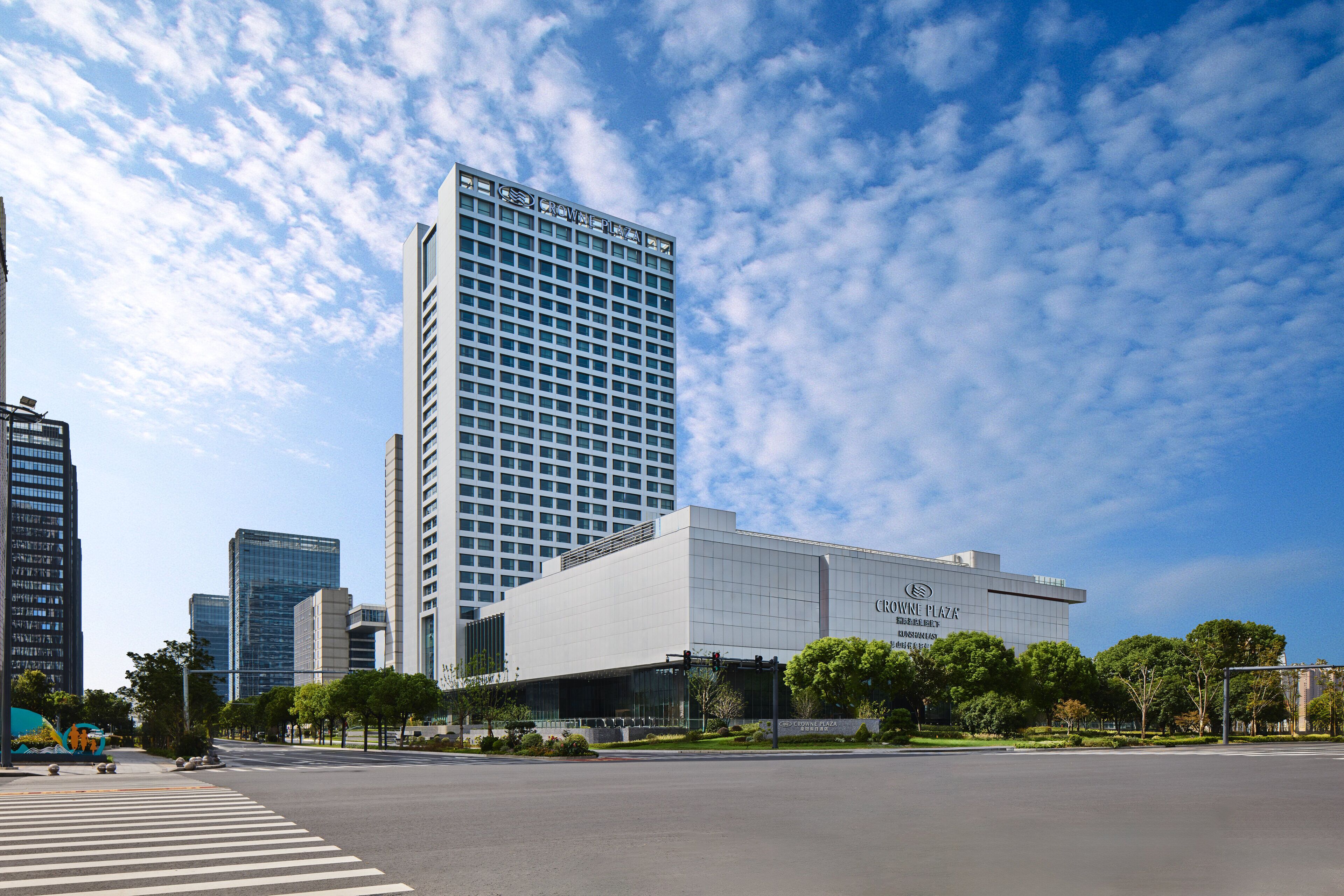 A modern building with a glass facade and a sign that reads "Crown Plaza."