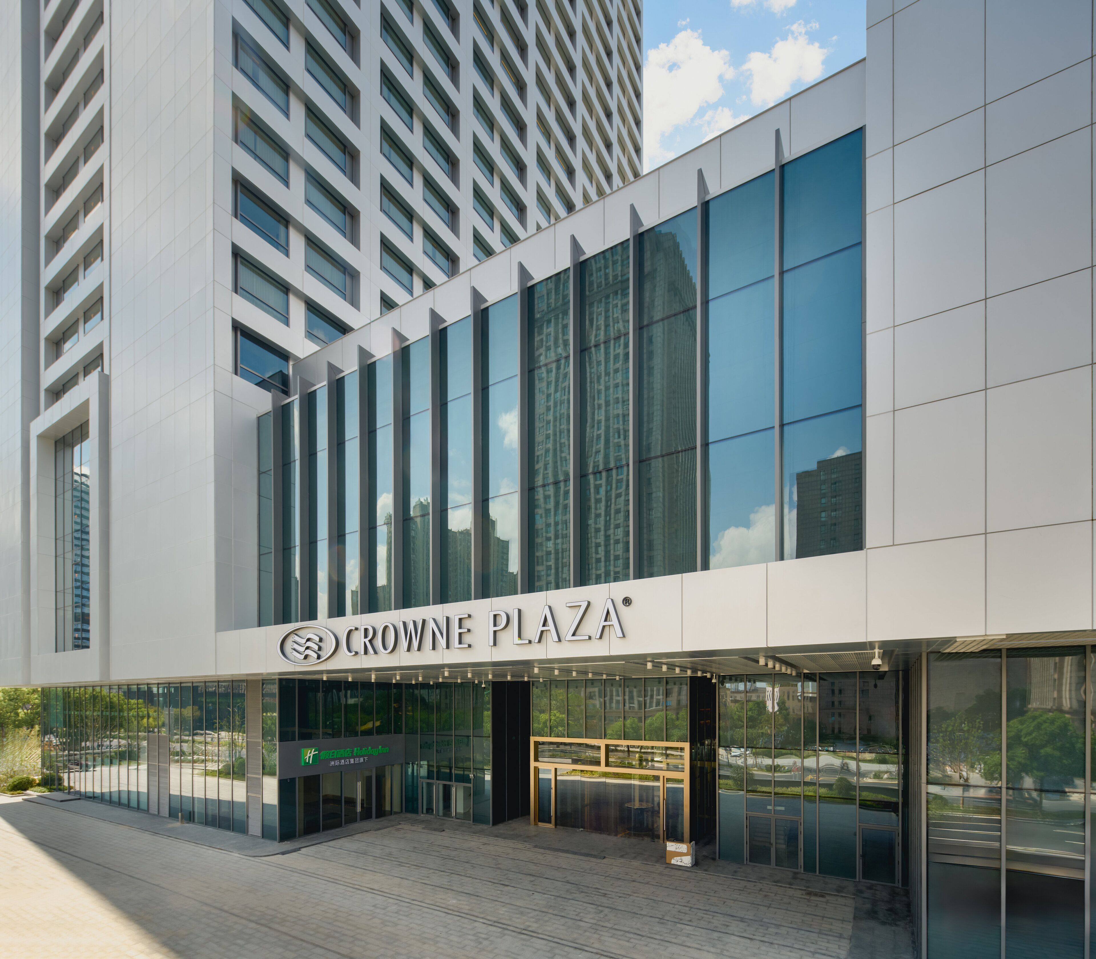 A modern building with a glass facade and the sign "CROWNE PLAZA".