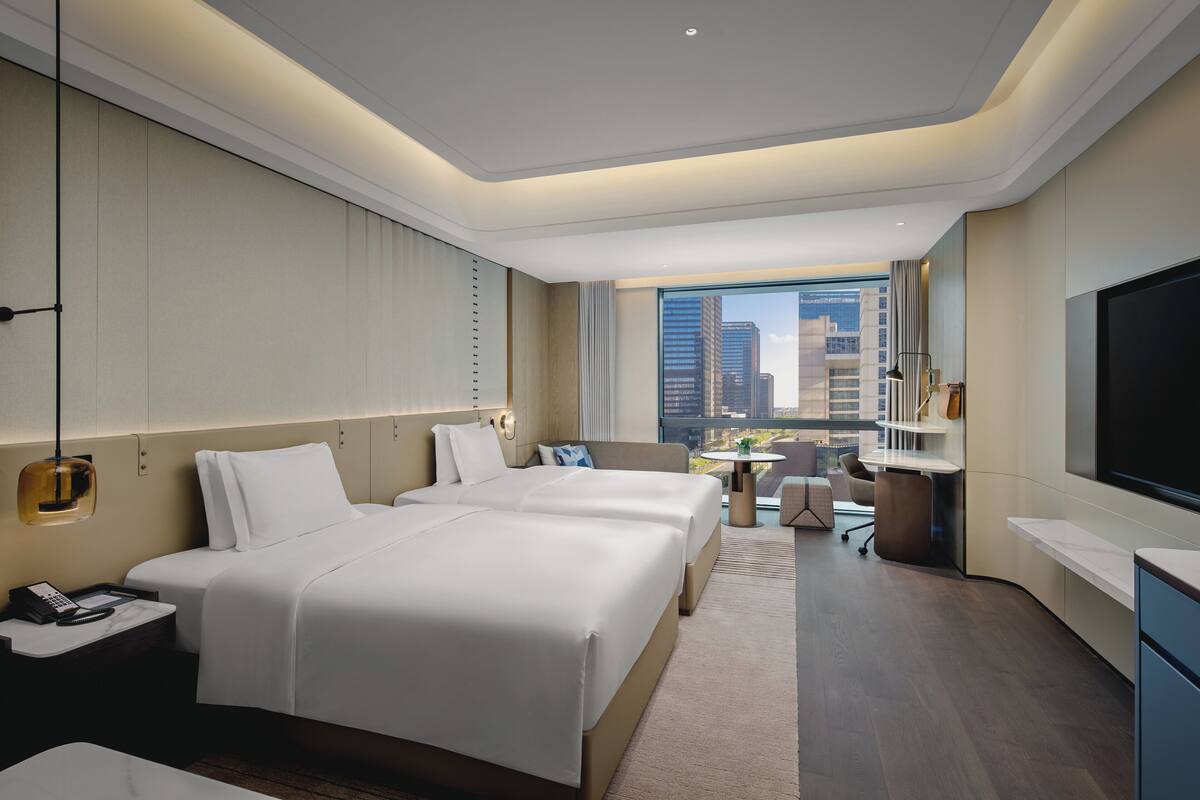 Relax in a spacious room with a large bed, flat-screen TV, and desk with city view.