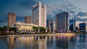 A modern cityscape with high-rise buildings and a reflective water body. - Crowne Plaza Kunshan East by IHG (Suzhou)