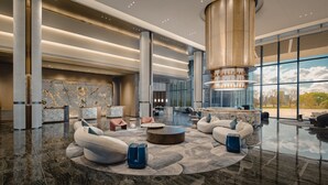 A spacious lobby with a central seating area, a reception desk, and a large window offering a view of the outdoors. - Crowne Plaza Kunshan East by IHG (Suzhou)