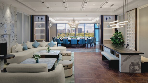 A spacious living area with a modern design, featuring a large sofa, a dining table with chairs, and a view of the cityscape through large windows. - Crowne Plaza Kunshan East by IHG (Suzhou)