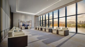 A spacious hotel lobby with a long row of seating, large windows offering a city view, and a modern ceiling design. - Crowne Plaza Kunshan East by IHG (Suzhou)